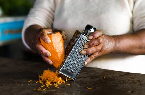 Hände einer Frau, die die Karotte kratzt — Stockfoto