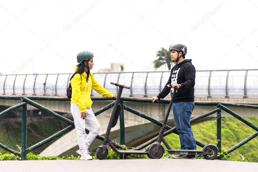 Two smiling friends showing helmet