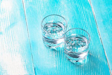 alkol arka plan mavi boyalı ahşap çerçeve ortasında altında iki bardak