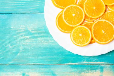 bir tabak meyve portakal parçası Yüzükler, mavi bir arka plan tabağa dilimlenmiş