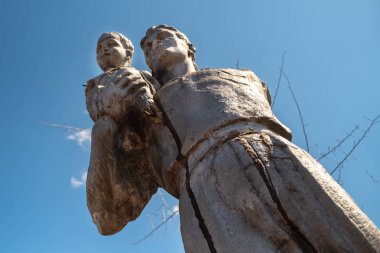 Eski kırık anıt heykel kez SSCB baba ve eller oğlu, mavi gökyüzü ve dalları üzerinde dışarı arkadan