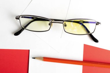 gözlük ve kırmızı kalemle notlarda notlar