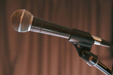 Konser, yan görünümü kahverengi arka plan aşamasında üzerinde mikrofon