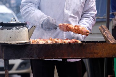 kirli eldiven fry Barbekü ızgara, ızgara su ısıtıcısı, duman ve şampuanlar yanında sokak erkekte üzerinde