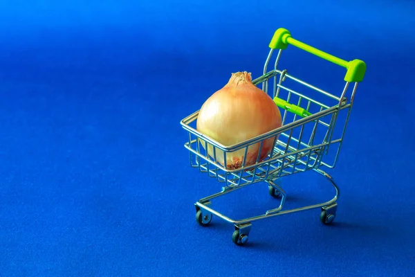 在蓝色布料背景有一个篮子从超级市场他们放置了一个粗灯泡 黄色在蓝色 — 图库照片