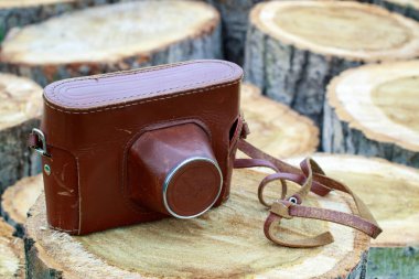 ahşap kütükler üzerinde kamera, ahşap eski film kamera ile deri çanta
