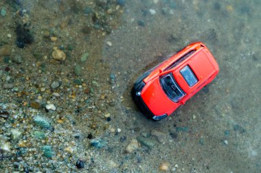 deniz, kum ve plaj tarafından suda olmak kırmızı araba oyuncak üstten görünüm