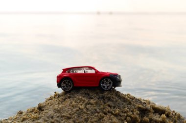 üzerinde kırmızı bir oyuncak araba içinde belgili tanımlık geçmiş deniz kum yığını bir çerçeve merkezinde