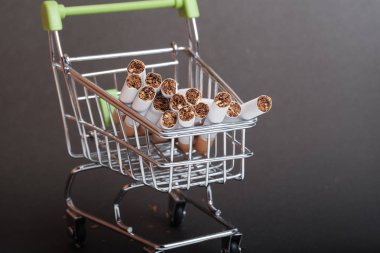 cigarettes in the basket for supermarket are tobacco forward, the dark background purchase cigarettes clipart