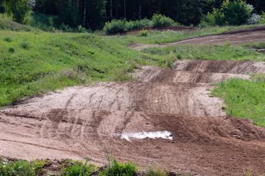 motokros, çimenler ve ağaçlar büyüyen yol kenarları boyunca tepelere kirli yol
