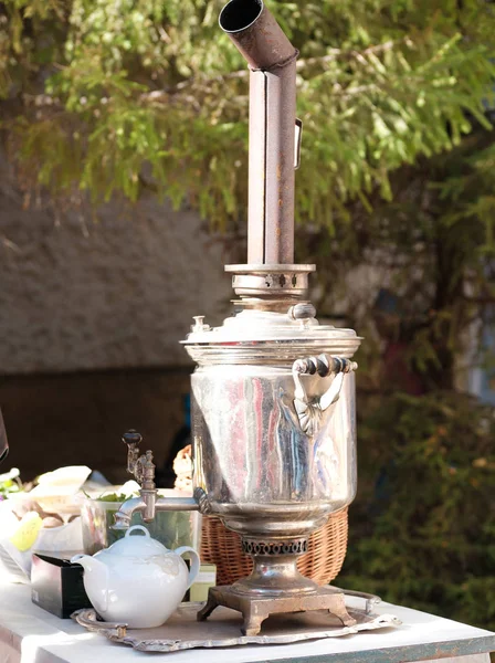 old shiny Russian samovar for tea brewing, tea party in the open air in Russian traditions