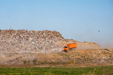mavi gökyüzü ve üzerinde turuncu sürmek büyük bir dökümü çöp kamyonu kamyon