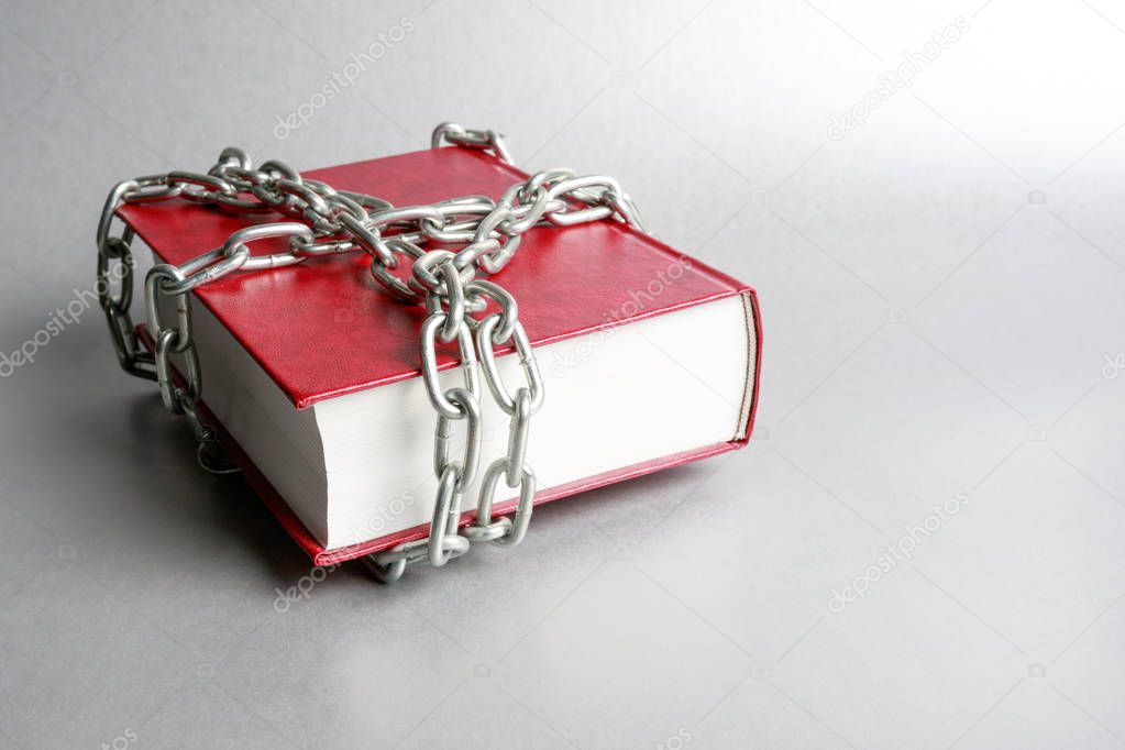 on a gray background is a red book wrapped around a metal chain