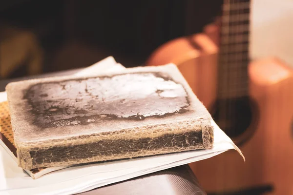 Die Blätter und das Buch im alten Einband auf der Hintergrundgitarre — Stockfoto