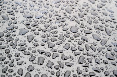 karanlık yüzeyde düzensiz su damlaları, farklı şeklin damlaları