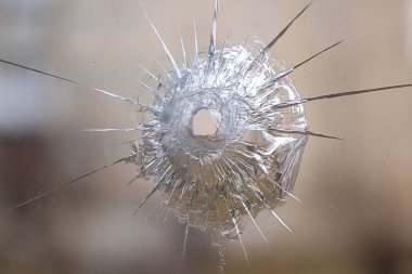 the mark of the shot from the bullet on the glass in the room, the background is blurred clipart