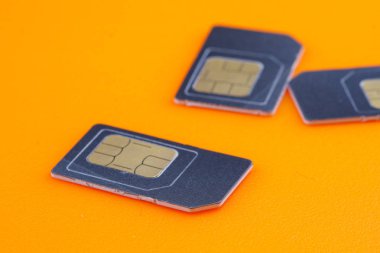 turuncu arka planda telefon için gri sim kartlar