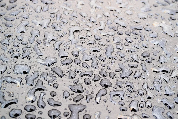 Gocce d'acqua in diverse forme, macro fotografia gocce d'acqua di forma irregolare sulla superficie scura — Foto Stock