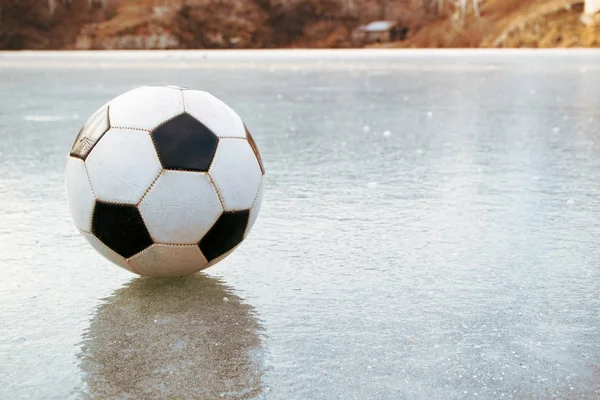 Pelota de fútbol clásico en un estanque congelado —  Fotos de Stock