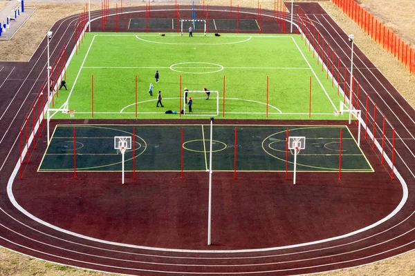 Campo de fútbol está vallado con una rejilla, vista superior y lateral del campo es jugado por los niños —  Fotos de Stock