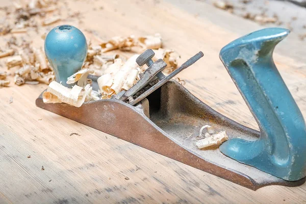 hand tool planer on wood surface and wood shavings around