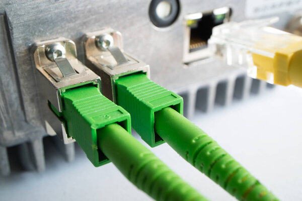 two green optical patch cords inserted into the green optical ports
