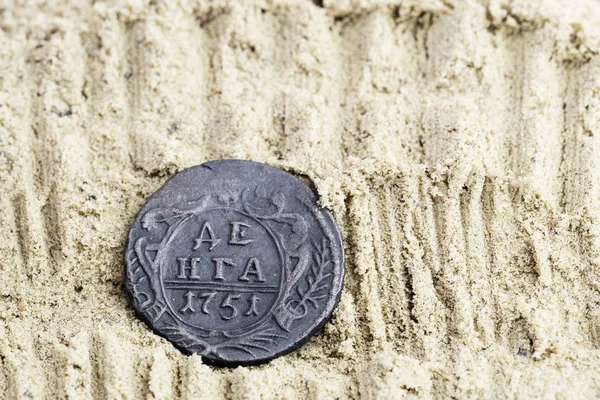 Медные монеты в песке с надписью Denga 1751 выпуска, старинные русские медные монеты — стоковое фото