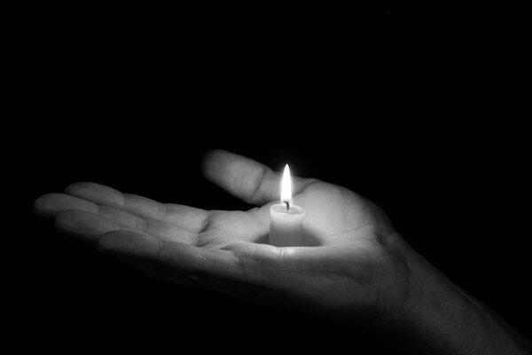 black and white photograph of the palm where the candle is burning