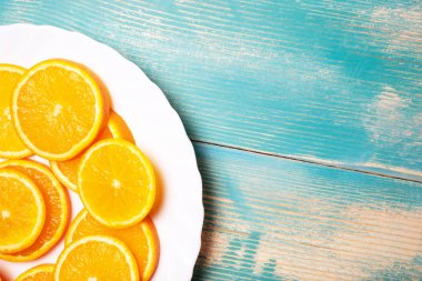 Ahşap tahta üzerinde turuncu dilimleri ile beyaz plaka