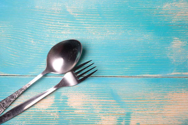 Metal spoon and fork from stainless steel are from the edge of the frame on a wooden sotle — Stock Photo, Image