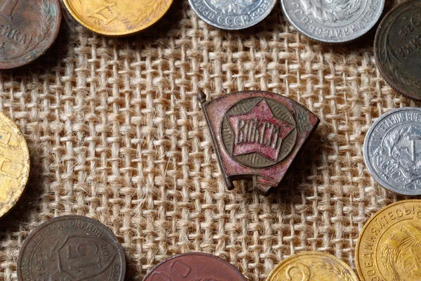 Tiempos de la URSS icono del Komsomol rodeado de monedas soviéticas — Foto de Stock