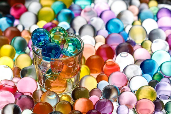 Em vez de álcool derramado em um copo de bolas de hidrogel de cores diferentes — Fotografia de Stock