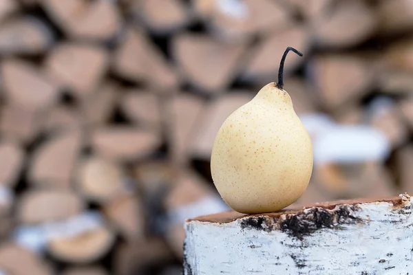 Op een houten berken stomp Chinese peer, gele peer op een achtergrond — Stockfoto