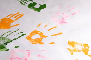 beyaz kağıda farklı renklerle bırakılan çocuk ellerinin baskıları, çocuk yaratıcılığı