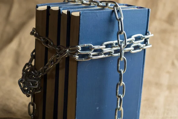 Los libros en encuadernación azul están cubiertos con una cadena de metal, una cadena en forma de cruz — Foto de Stock
