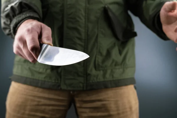 Knife in the center of the frame in the hands of a man, the man himself out of focus — Stock Photo, Image