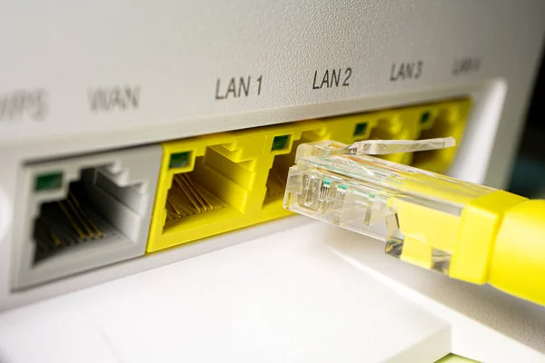 Žlutá šňůra Pat je vložena do volného portu routeru — Stock fotografie