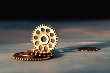 mavi ahşap yüzeyde farklı boyutta dişliler parlak tarafından aydınlatılır