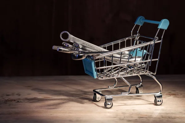 Il carrello della spesa del supermercato pieno di chiavi è illuminato dall'alto da un punto di luce — Foto Stock