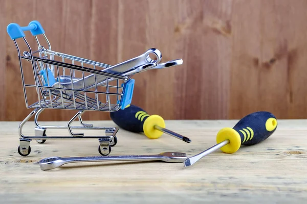 shopping cart from the supermarket filled with wrenches nearby are screwdrivers