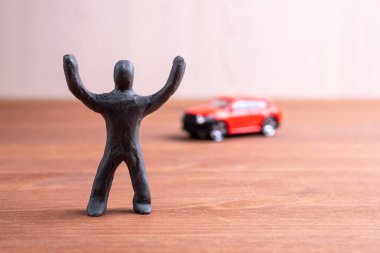 plastik adam bir oyuncak araba arka plan karşı sevinir