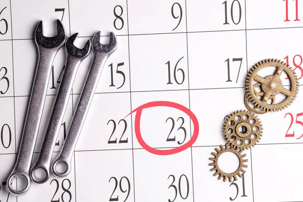 gears and three chrome spanners on a calendar with monthly dates