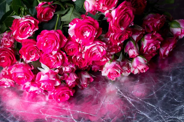 small striped roses lying in a large bouquet on the reflecting