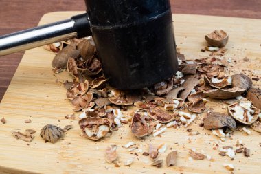 sarı renk bir kesme tahtası üzerinde bir çekiç ezilmiş fındık yakın çekim, ezilmiş fındık