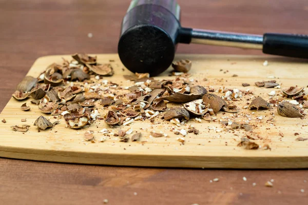 Verpletterd alle noten op de tafel volgende is de hamer op de houten tafel hakken Board — Stockfoto