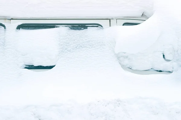 a minibus covered with snow are visible only to the side of the glass