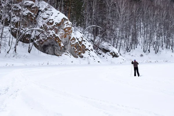 Skier in the winter forest skiing along the rocky — Stock Photo, Image