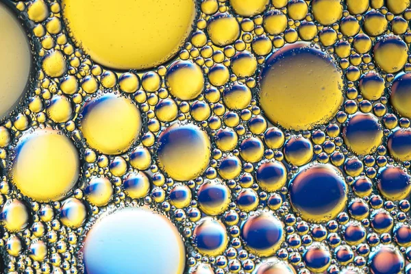 Sfondo blu-giallo di bolle di sapone su macro acqua — Foto Stock