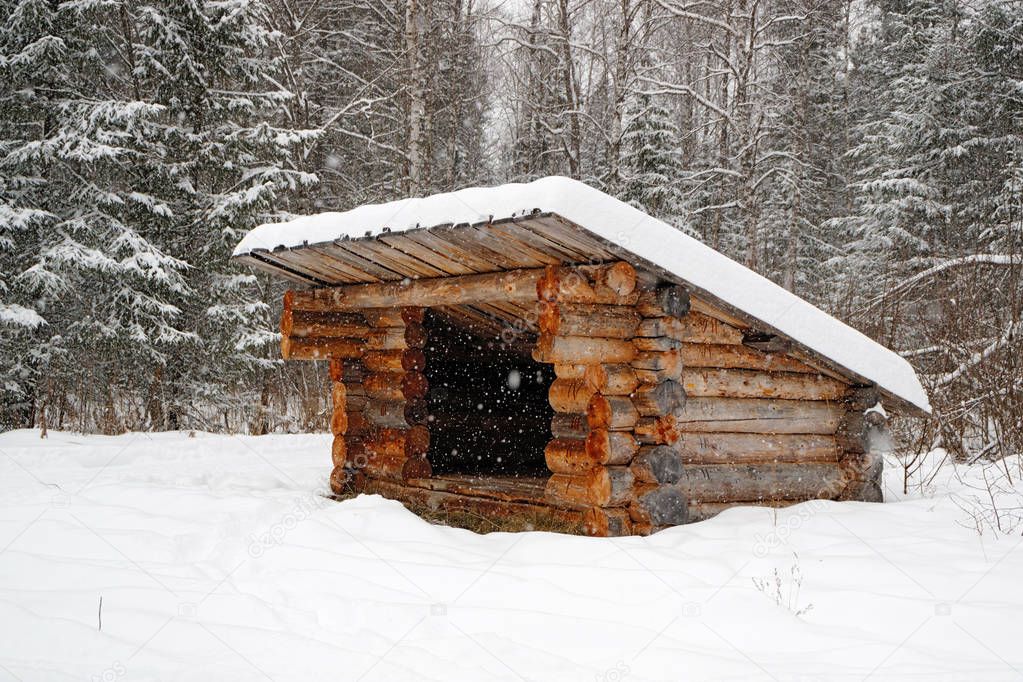 a refuge for partisans in the forest in winter, a structure of logs with a roof