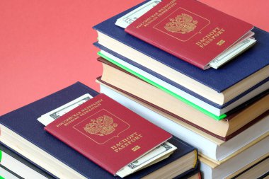 içinde para olan iki pasaport kitap yığınları üzerinde